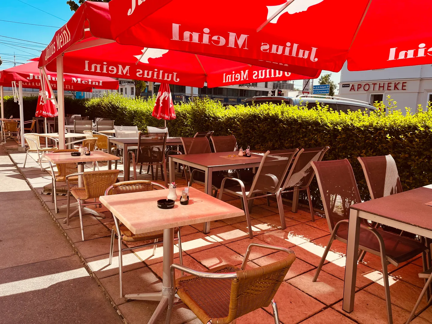 Sonniger Gastgarten mit Schirmen
